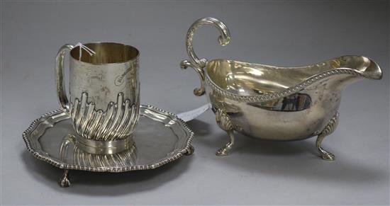 A silver oval gravy boat, a half spiral-reeded silver Christening mug and a circular silver waiter approx 20oz gross